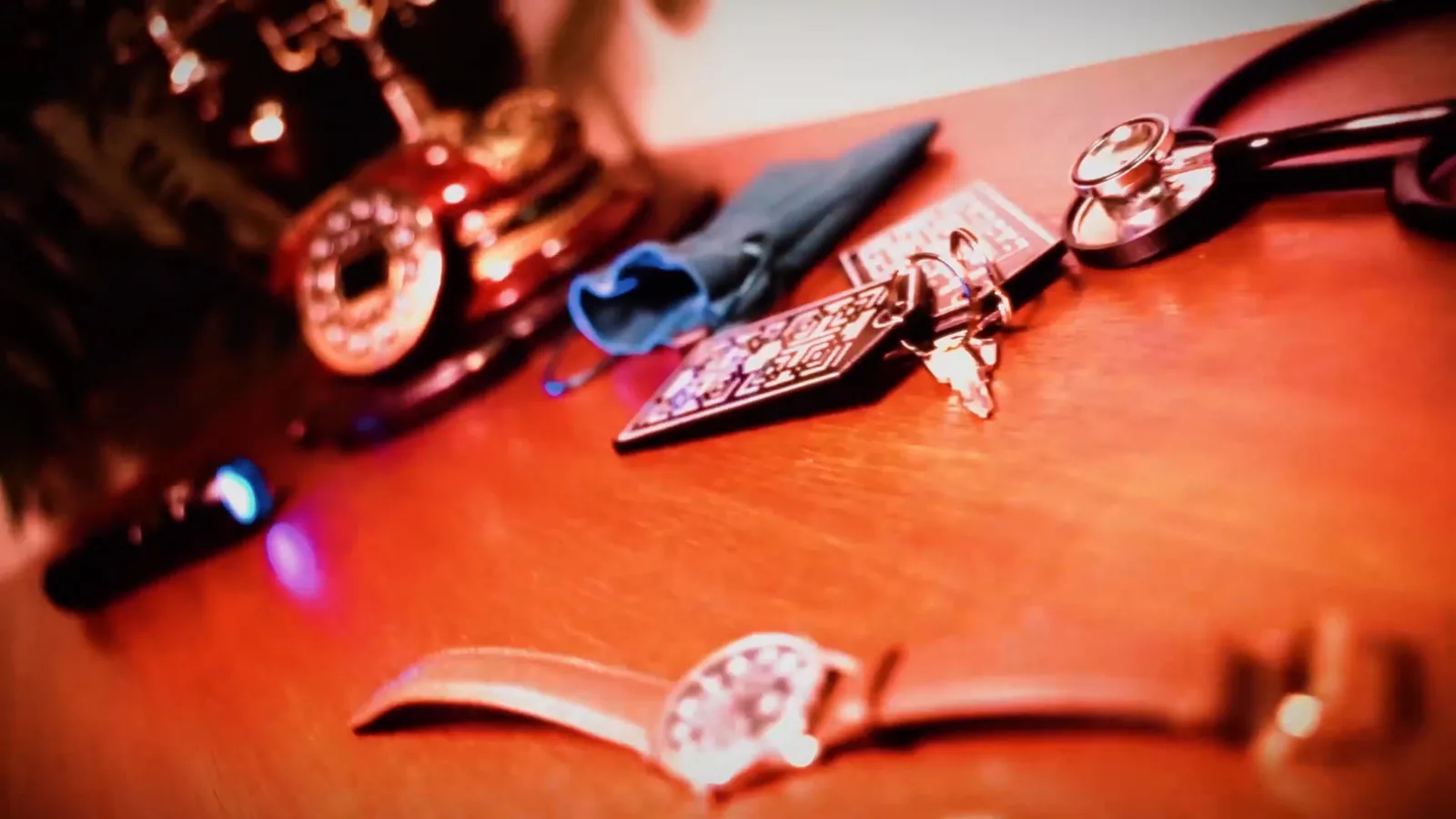 A rotary phone, keys and a wristwatch on a bank manager’s desk in Bank Heist